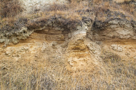 natural photo of a cut of a layer of earth and clay on a cliff