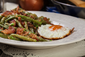 Healthy sauteed green beans with bacon and fried egg