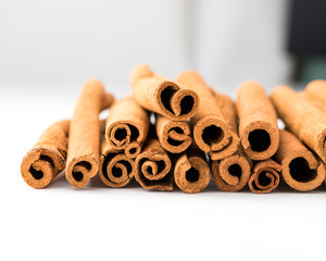 Cinnamon sticks lined up in a row on white background. Suitable for health and regimen-themed studies.