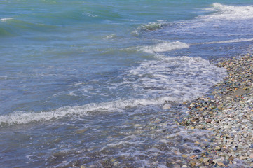 pebble coastline. Seashore with transparent water and small stones
