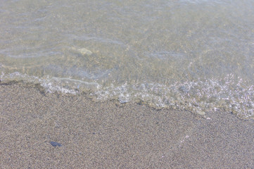 pebble coastline. Seashore with transparent water and small stones.