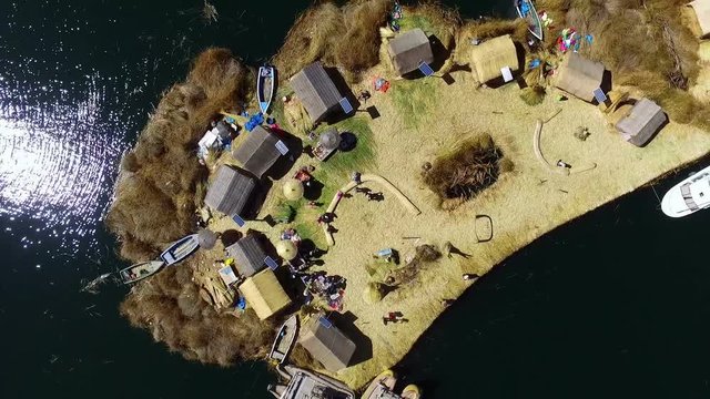 Uros floating islands in Peru aerial drone top point of view. The Floating Islands are small, man-made islands constructed by the Uros people from layers of cut totora in the shallows of Lake Titicaca