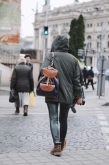 Rear view of a hipster girl with a backpack on her back