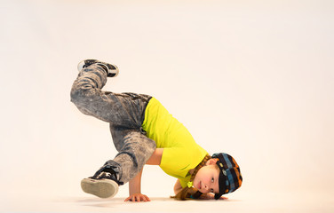 a little girl performs breakdance, a child in a unique acrobatic dance pose,bgirl in action