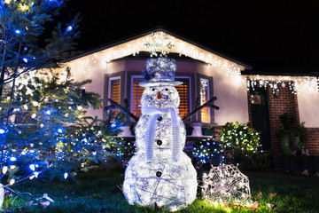 Christmas decoration representing a snowman displayed in front of a house;