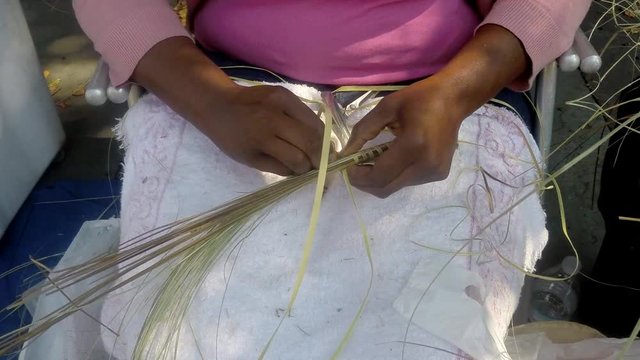 Black woman's hands working with sweetgrass