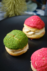 christmas choux cream or cream puff or French profiteroles with fresh cream set on cafe table.