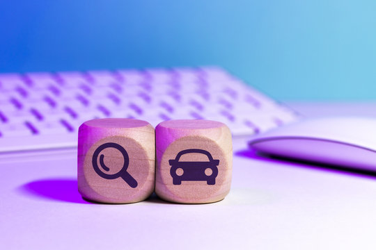 Recherche de voiture sur internet - Icone de loupe et de voiture sur cube en bois devant un clavier et une souris