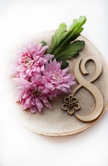  pink flowers on March 8 on a wooden background