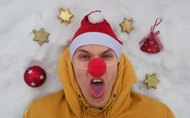 Guy in the image of Santa is lying on the snow around him Christmas toys and shows different...