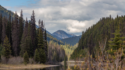 Snowy mountains with a lake at the bottom and cloudy sky