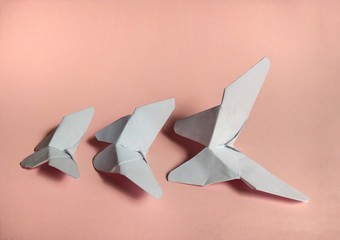 White paper butterflies on pink background. decorative concept