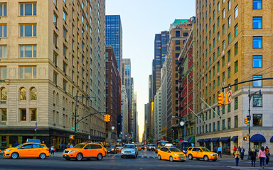 Yellow taxi on road. Street view in Financial District of Lower Manhattan, New York of USA. Skyline...