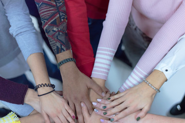 College Students Teamwork Stacking Hand Concept. Close up of young people putting their hands together. Friends with stack of hands showing unity and teamwork.
