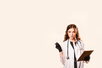 happy beautiful female doctor in medical coat .Writes a medical history in notebook. with a...