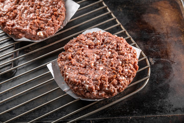 Raw vegetarian hamburger patties on grill