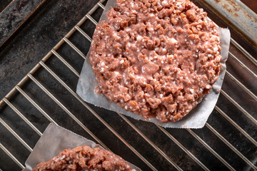 Raw vegetarian hamburger patties on grill