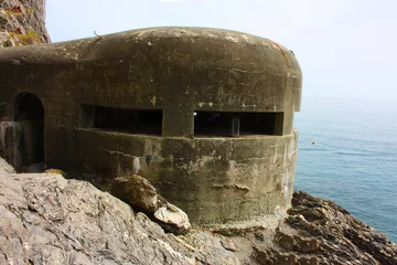 Fotobehang old german bunker from the second world war on a cliff overlooking the sea at cinque terre in monterosso in liguria © Alessia