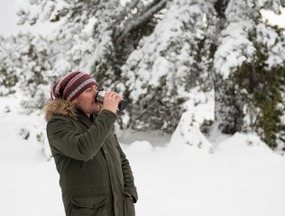 Handsome young man is drinking coffee with thermos mug and enjoying snow in winter season. Winter in Eskisehir.