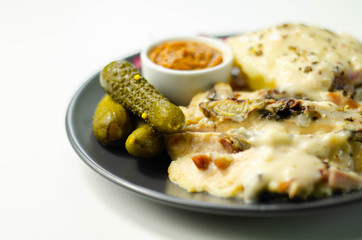Chicken breast with sliced mushrooms, ham, in cheese sauce with mash potato, pickled red cabbage, and gherkin
