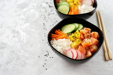 Close up of two poke bowls with salmon and vegetables