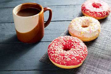 Morning breakfast. Colorful donuts and chocolate cup on dark wooden background.