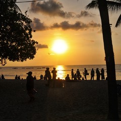 silhouette of people walking on the beach at sunset