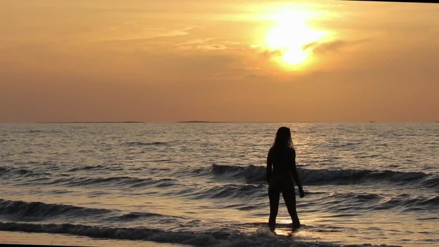 Girl walks on the tropical sandy beach in sunset,Kho Kho Khao, Thailand
