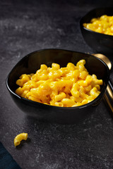 Mac and cheese in black plates on dark background