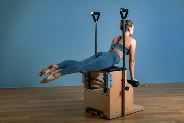 Pilates woman in a reformer doing stretching exercises in the gym. Fitness concept, special fitness...
