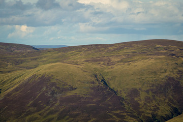 View looking east above Glen Doll towards upland Scottish mountain plateau with white clouds above