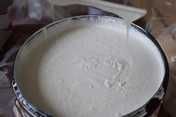 White paint in a large container for painting a room. Concept: repair and decoration.