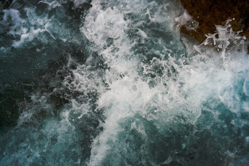 Obraz premium Raging blue water in a backwater with stones and white foam.