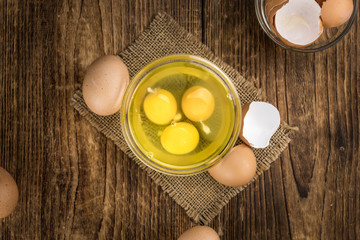 Wooden table with Raw Eggs (detailed close-up shot; selective focus)