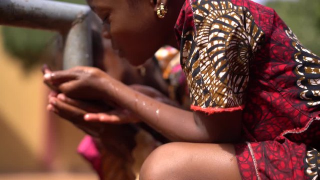 Two Funny Little African Girls Playing Around With Water At The Village Pump