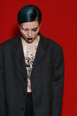 Studio photoshoot of a beautiful girl with blue hair and a fashion make-up in a black jacket. Fashion style