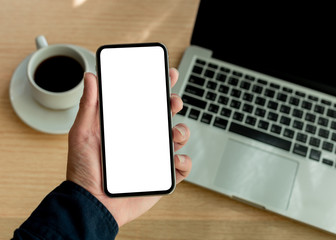 Mockup image blank white screen cell phone.man hand holding texting using mobile on desk at office.background empty space for advertise text.people contact marketing business,technology 