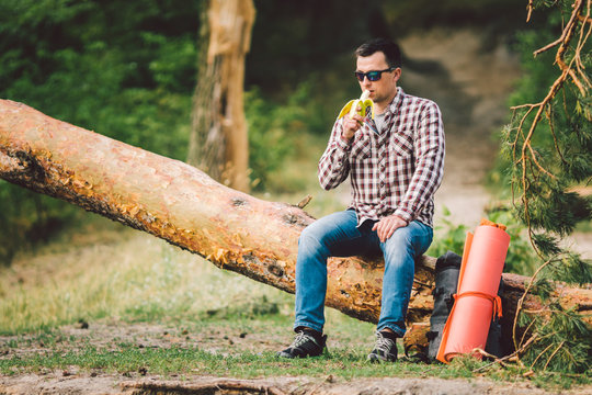Eating banana Outdoors Hiking Trail. theme hiking and nature travel. Tourist take a rest and eating babanas. picnic in the forest. tourist eat snack food. Vitamin charge