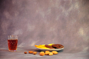 Crystal glass with cognac plate with slices of lemon and pieces of chocolate and a scattering of...