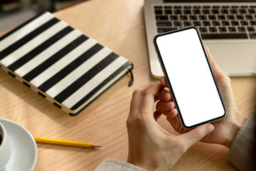 Mockup image blank white screen cell phone.man hand holding texting using mobile on desk at office.background empty space for advertise text.people contact marketing business,technology 