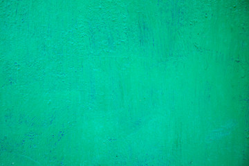 Fototapeta na wymiar The texture of the iron wall, covered with green oil paint with traces of existence.