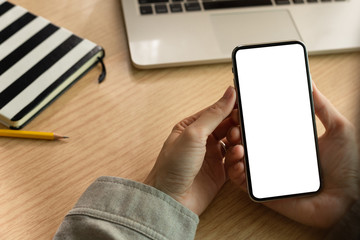 Mockup image blank white screen cell phone.man hand holding texting using mobile on desk at coffee shop.background empty space for advertise text.people contact marketing business,technology 