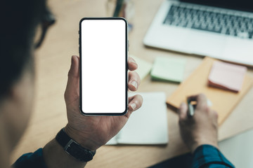 Mockup image blank white screen cell phone.man hand holding texting using mobile on desk at coffee shop.background empty space for advertise text.people contact marketing business,technology 