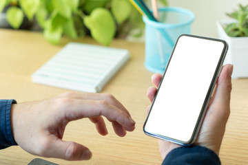 Mockup image blank white screen cell phone.man hand holding texting using mobile on desk at coffee shop.background empty space for advertise text.people contact marketing business,technology 