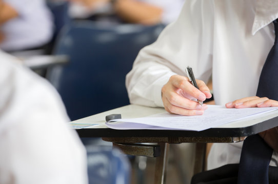 high school,university student study.hands holding pencil writing paper answer sheet.sitting lecture chair taking final exam attending in examination classroom.concept scholarship for education abroad