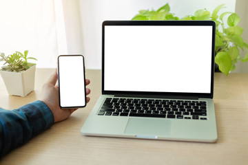 Fototapeta premium mockup image blank screen computer,cell phone with white background for advertising text,hand man using laptop texting mobile contact business search information on desk in office.marketing,design