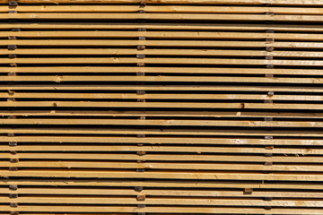 Close up and side view of a pallet filled with treated and milled pine wood planks. Natural building and construction industry materials filling frame.