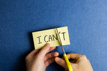 I can do it. Positive motivation concept. Remove 't' from the word 'I can't' with scissors.