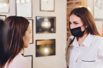 beautician- makeup artist applies paint henna on previously plucked, design, trimmed eyebrows in a...