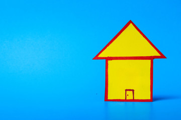 Fototapeta na wymiar yellow cartoon house cut out on blue background